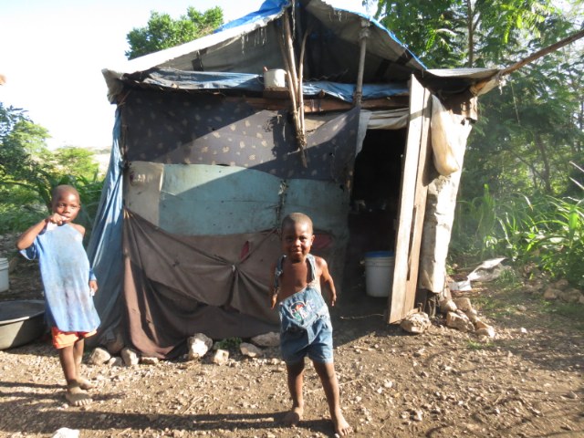 A precious Haitian boy outside his home